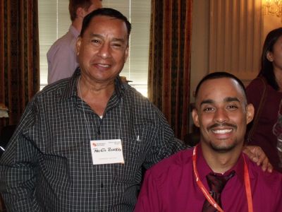 Two Hispanic men smiling at a conference