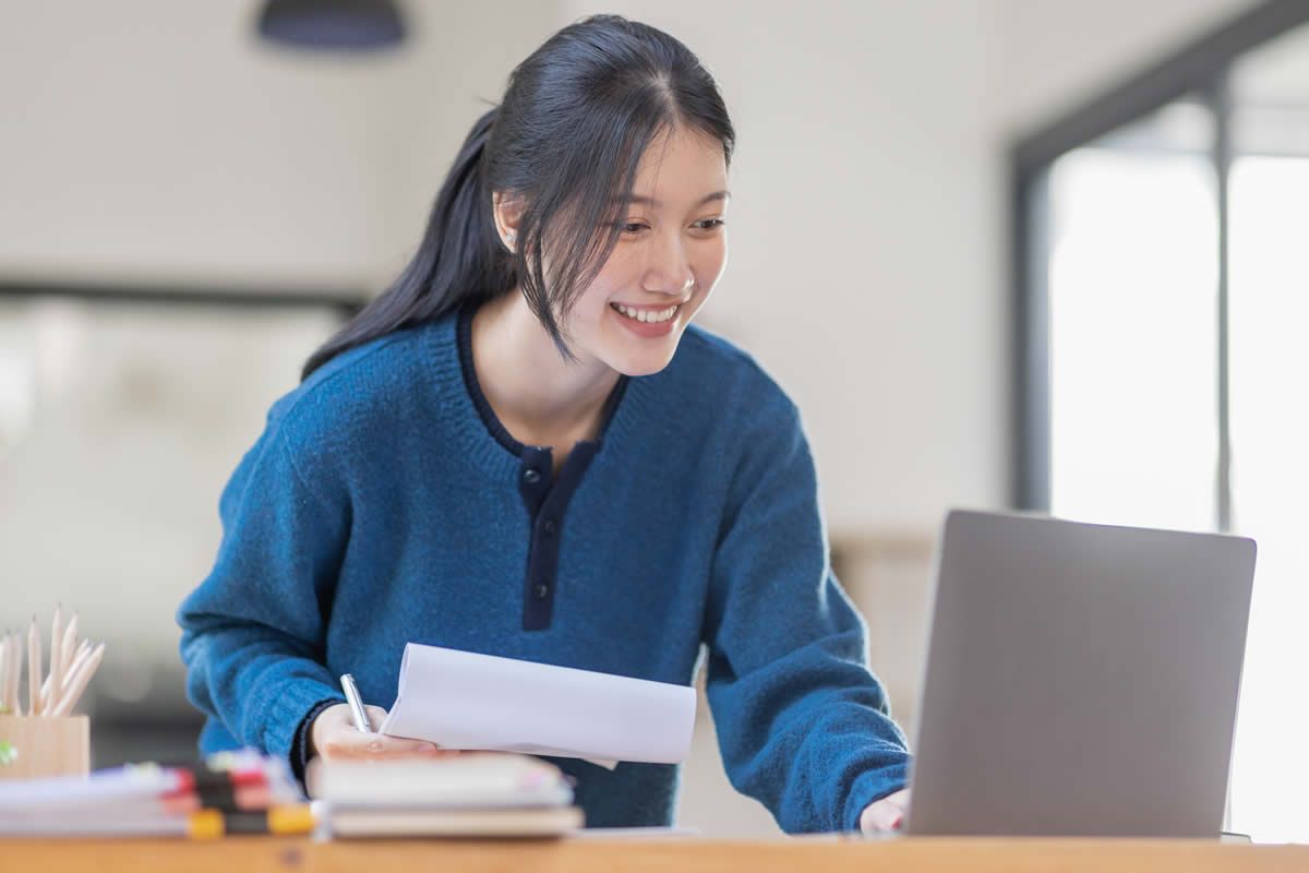 Young woman smiling and working at computer 