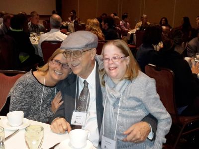 A smiling family of 2 parents and a daughter 