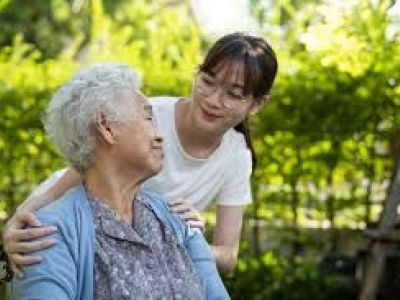 An Asian woman wearing glasses helps an older Asian woman